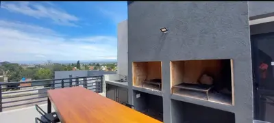 a balcony of a building with a wooden table at Dpto en Carlos Paz con vista al Lago in Villa Carlos Paz