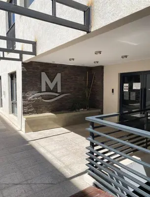 a building with a sign on the side of it at Dpto en Carlos Paz con vista al Lago in Villa Carlos Paz