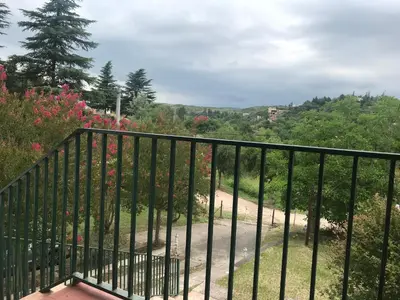 a balcony with a black fence and flowers at Casa de Beto Estancia Vieja in Estancia Vieja