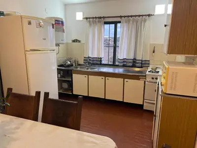 a kitchen with a white refrigerator and a sink at Casa de Beto Estancia Vieja in Estancia Vieja