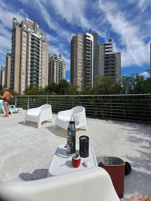 a table and chairs on a roof with tall buildings at Vista al Kempes in Cordoba