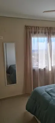 a bedroom with a mirror and a bed and a window at Vista al Kempes in Cordoba