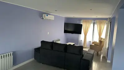 a living room with a black couch and a tv at La Palmerita !! in Cordoba