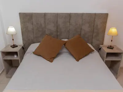 a bedroom with a bed with two night stands and two lamps at Depto 4 in Villa Carlos Paz
