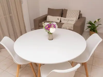 a white table with a vase of flowers on it at Depto 4 in Villa Carlos Paz