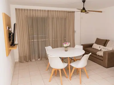 a living room with a table and chairs and a couch at Depto 4 in Villa Carlos Paz