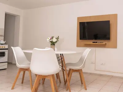 a dining room with a white table and white chairs at Depto 4 in Villa Carlos Paz
