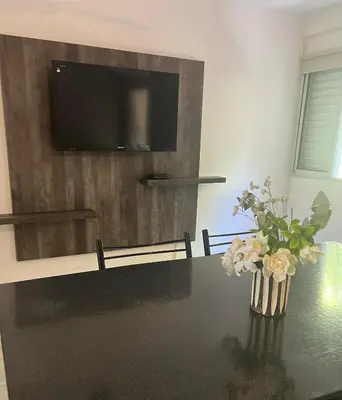 a dining room table with a vase of flowers on it at Depto 3 in Villa Carlos Paz