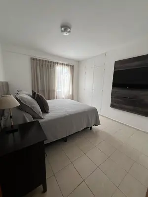 a bedroom with a bed and a desk and a television at Depto 3 in Villa Carlos Paz