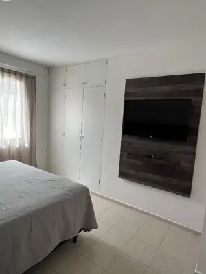 a bedroom with a bed and a flat screen tv at Depto 3 in Villa Carlos Paz