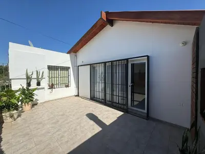 a white house with a patio with a door at Hermoso departamento en alquiler in Cordoba
