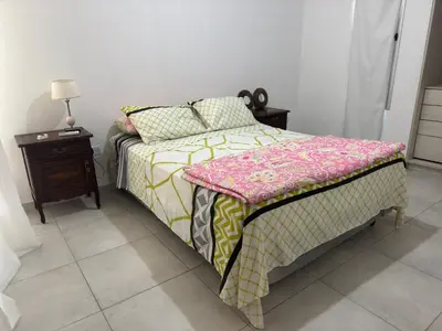 a bedroom with a bed with a pink and yellow blanket at Hermoso departamento en alquiler in Cordoba