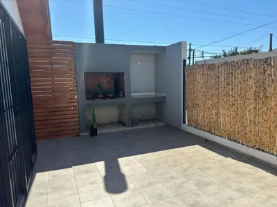 a patio with a fireplace and a wooden fence at Hermoso departamento en alquiler in Cordoba
