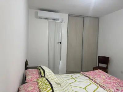 a bedroom with a bed and a chair and a mirror at Hermoso departamento en alquiler in Cordoba