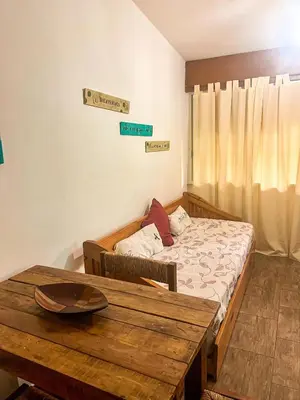 a bedroom with a bed and a wooden table at Depto 150 in Villa Carlos Paz