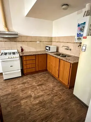 a kitchen with a white stove and a microwave at Depto 150 in Villa Carlos Paz
