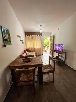 a living room with a table and a couch at Depto 150 in Villa Carlos Paz