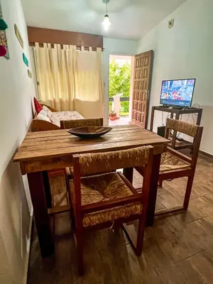 a wooden table and chairs with a television in a room at Depto 150 in Villa Carlos Paz