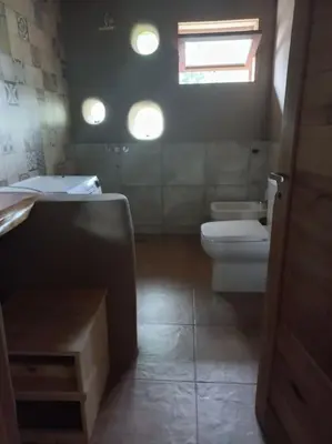 a bathroom with a sink and a toilet and a window at Hermosa casa amplia y luminosa in Villa Los Aromos