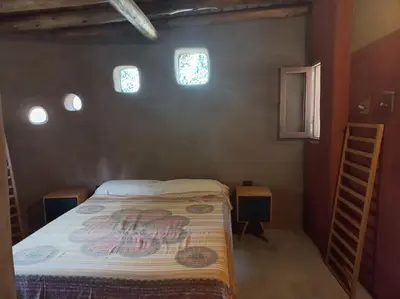 a small bedroom with a bed and two windows at Hermosa casa amplia y luminosa in Villa Los Aromos