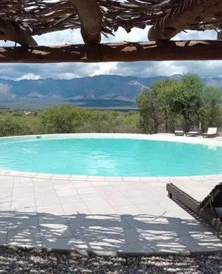 a large blue swimming pool with mountains in the background at Casa en La Comarca in San Javier