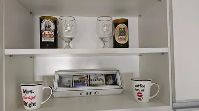 a shelf with wine glasses and a clock on it at Dpto 1 RaGi in Cordoba