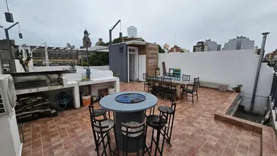 a patio with a table and chairs on a roof at Dpto 1 RaGi in Cordoba