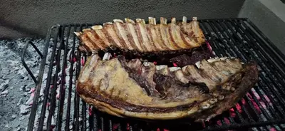 a piece of meat is cooking on a grill at Dpto 1 RaGi in Cordoba