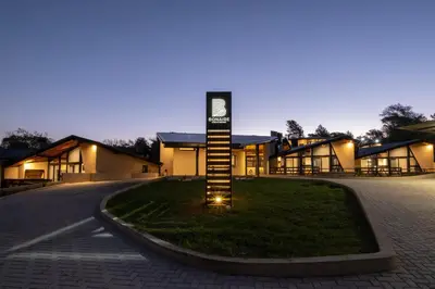 a building with a sign on the grass in front of it at Bonaire Aparthotel in Villa General Belgrano