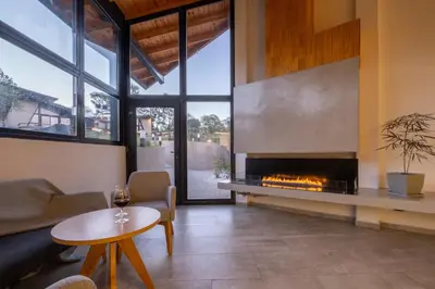 a living room with a fireplace and a table at Bonaire Aparthotel in Villa General Belgrano