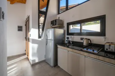 a kitchen with a refrigerator and a counter top at Bonaire Aparthotel in Villa General Belgrano