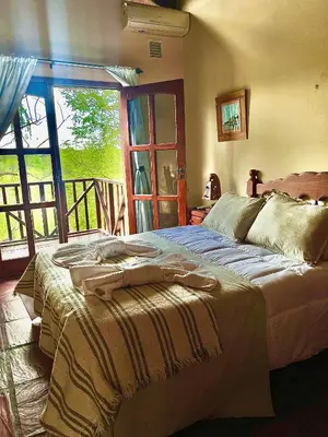 a bedroom with a bed in a room with a window at MIRADOR DE ESTRELLAS RESORT in Nono
