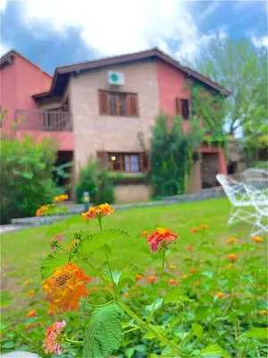 a house with a yard with flowers in front of it at MIRADOR DE ESTRELLAS RESORT in Nono