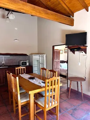 a kitchen and dining room with a wooden table and chairs at MIRADOR DE ESTRELLAS RESORT in Nono