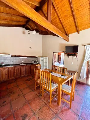 a kitchen with a wooden table and chairs at MIRADOR DE ESTRELLAS RESORT in Nono
