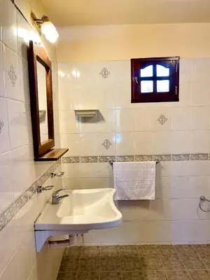 a bathroom with a sink and a mirror and a window at MIRADOR DE ESTRELLAS RESORT in Nono
