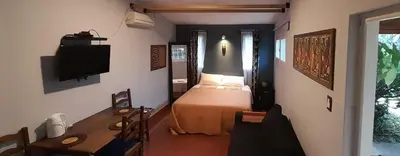 a bedroom with a bed and a table and a tv at Cerro de las Rosas in Cordoba