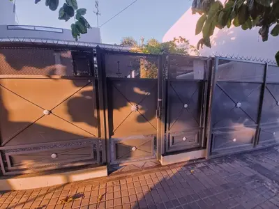 a black fence with a bunch of doors at Impecable departamento temporario en Córdoba in Cordoba
