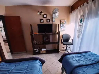 a bedroom with a bed and a tv and a chair at Impecable departamento temporario en Córdoba in Cordoba