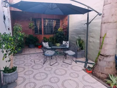 a patio with a table and chairs and an umbrella at Impecable departamento temporario en Córdoba in Cordoba
