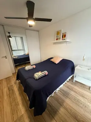 a bedroom with a large blue bed with a ceiling at Departamento en el centro - Lake Tower in Villa Carlos Paz