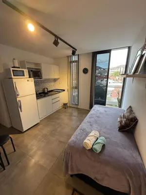 a bedroom with a large bed with two towels on it at Departamento en el centro - Lake Tower in Villa Carlos Paz