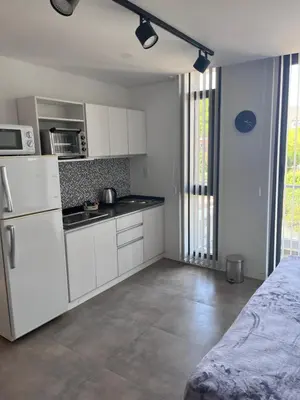 a kitchen with white cabinets and a white refrigerator at Departamento en el centro - Lake Tower in Villa Carlos Paz