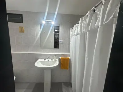 a bathroom with a sink and a white shower curtain at Buena Vista Icho Cruz in Villa Icho Cruz