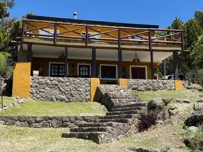 a house with a stone wall and stairs in front of it at Buena Vista Icho Cruz in Villa Icho Cruz