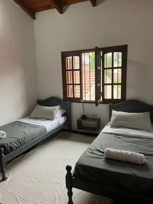 two beds in a room with two windows at Duplex del Cerro in Cordoba