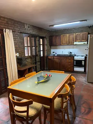 a kitchen with a wooden table with chairs and a counter at Duplex del Cerro in Cordoba