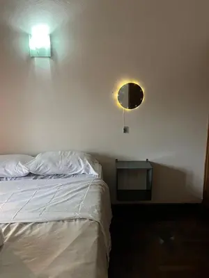 a bedroom with a bed and a light on the wall at Duplex del Cerro in Cordoba
