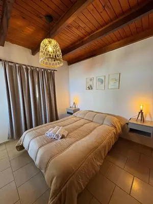 a bedroom with a large bed with two towels on it at Complejo Arenas in Alta Gracia