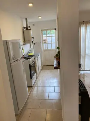 a kitchen with a white refrigerator and a tile floor at Complejo Arenas in Alta Gracia